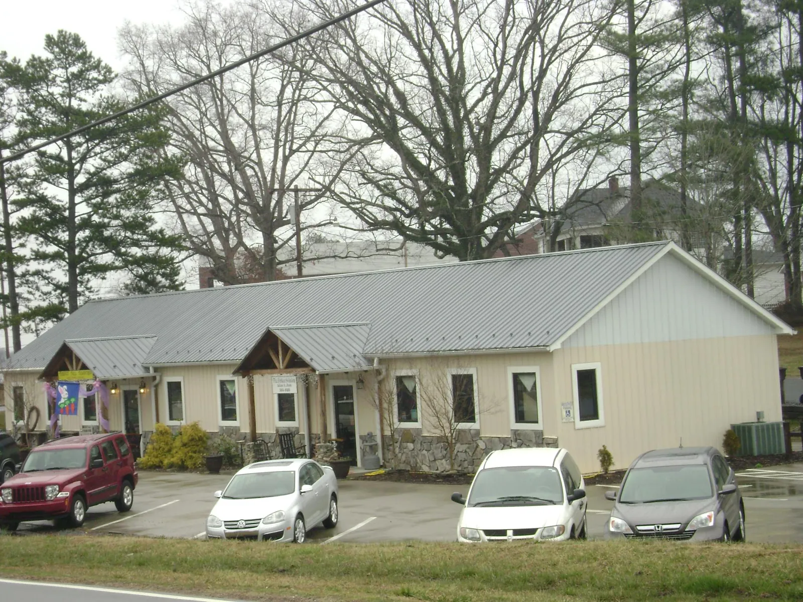 Gray metal roof with timber entry brackets on a small commercial building in Rocky Hill